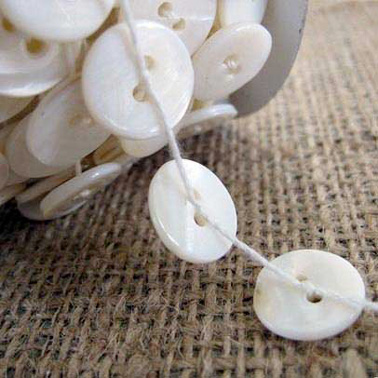 Pour Noël, personnalisez votre déco et fabriquez de jolies guirlandes avec des boutons et du fil pour votre sapin ou votre table table le soir du réveillon !