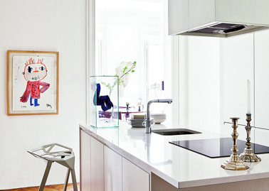  Dans une cuisine blanche une plaque de cuisson et un évier noir c'est sobre et chic. Le dessin croché au mur apporte la seule touche de couleur dans cette cuisine design