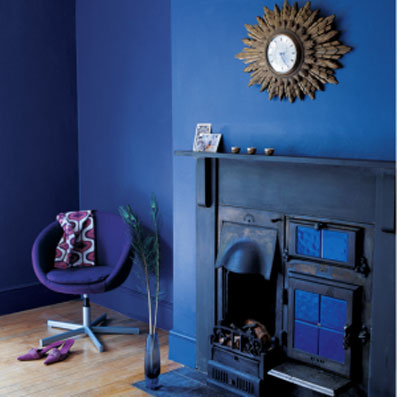 decoration salon tout en bleu : peinture murale, cheminée et fauteuil en contraste avec l'aspect chaleureux du parquet blond
