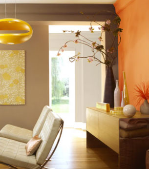 la decoration d'un salon avec peinture murale orange et taupe, un canapé cuir design ton ecru, meuble bas en hetre massif