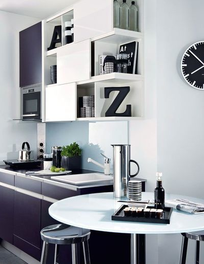 L'aménagement futé d'une petite cuisine noire et blanche ouverte sur le salon avec des meubles hauts multifonctions permettant de ranger vaisselle et accessoires de décoration. Cuisine Darty