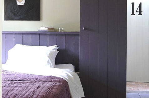 ambiance intime pour recevoir les amis avec une peinture chambre couleur violet pour peindre le lambris et la porte. Sur le haut des murs de cette chambre conviviale, une peinture gris perle est une bonne alternative au blanc pur.
