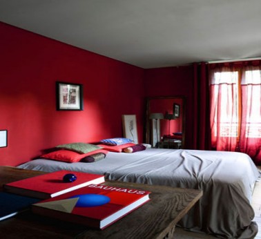 Décoration chambre adulte avec peinture murale couleur rouge finition satin, rideaux et oreillers meme rouge 