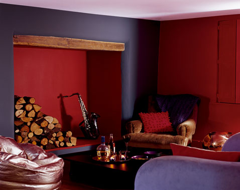 Ambiance campagne chic pour la décoration d'un salon avec peinture couleur violet et rouge pourpre, canapé et fauteuils nuance de violet