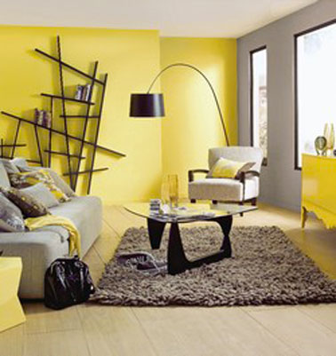 Une belle luminosité dans ce salon design autour de la couleur jaune et du gris. Sur le mur qui entoure les fenêtres un gris perle illuminé par le buffet bas d'un jaune vif finition laque