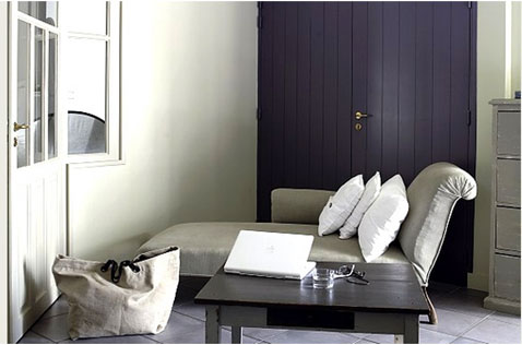 Une déco de petit salon qui renforce la douceur du gris dominant sur le murs et la méridienne avec une touche de couleur violet utilisée pour peindre la porte. 