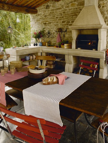cuisine d'été d'exterieur style rustique table de jardin en bois barbecue en pierre dans cheminee