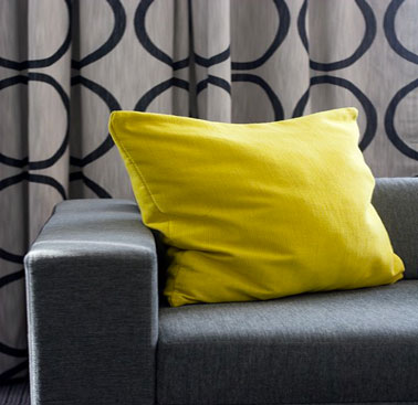 Pour dynamiser un canapé gris anthracite dans un salon à dominante grise rien de mieux que des coussins d'une belle couleur jaune vif qui apporte peps et luminosité