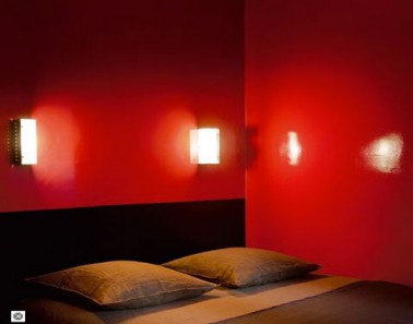 Décoration chambre adulte peinture murs rouge vif tête de lit peinture laquée noir, linge de lit et coussin brun et marron 