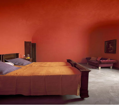 Decoration chambre rouge sur murs et plafond, linge de lit coton couleur orange coussin violet, meuble wengé