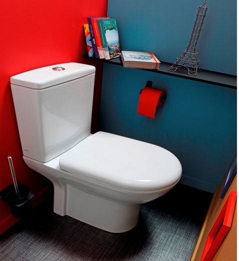 Une déco WC haute en couleur avec une association de peinture bleu et rouge vif et d’un sol PVC gris et d’une cuvette WC blanche 