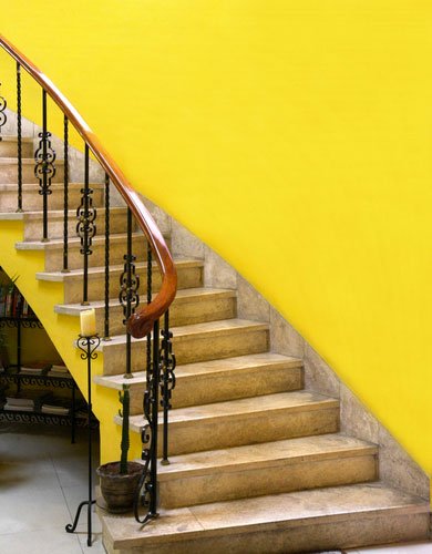 Une couleur jaune avec la peinture de l'escalier pour apporter de la lumière dans la montée d'escalier mise en valeur par les marches en pierres blondes