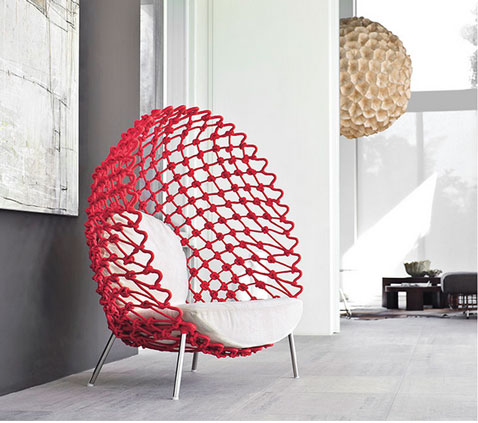fauteuil coque très design la structure en tissu tordu de couleur rouge est montée sur de l'acier, coussin assise et dos tissu blanc