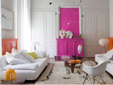 marier couleur peinture orange blanc et fuchsia dans salon Un salon dans lequel le blanc domine avec la couleur de la peinture murale et celle du canapé cuir. Pour donner une dynamique à la pièce, le soubassement est peint en orange et l'ancienne cheminée en peinture fuchsia finition satin