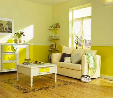 Dans ce salon, le tapis peint directement sur le parquet bois chêne clair avec une peinture pour sol et un pochoir frise souligne la fraicheur de l’harmonie couleurs jaune et ivoire.