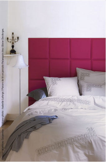 Ambiance romantique pour cette chambre avec une tête de lit réalisée avec des carreaux de cuir capitonnés couleur fuschia, parure de lit en percale blanc chez Olivier Desforges