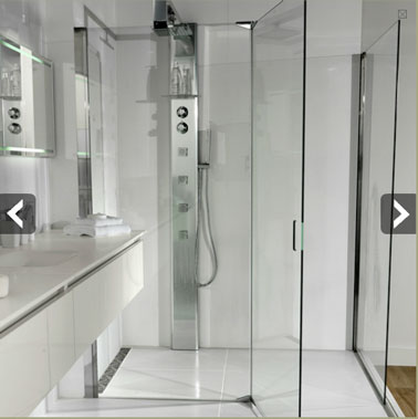 Pour aménager une salle de bains couloir, une douche italienne installée en enfilade du lavabo est idéale. pour agrandir l'impression d'espace, un carrelage sol et mur blanc est idéal.