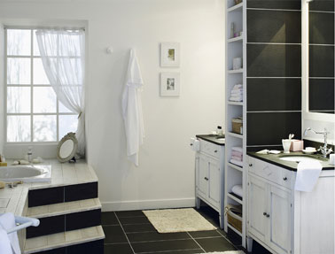Mélange de style dans la salle de bains en noir et blanc avec un mobilier esprit rétro finition blanc modernisé avec le carrelage au sol en noir ardoise.