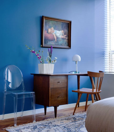 Une chambre aux couleurs apaisantes avec une peinture murale bleu cobalt, bureau et chaise couleur acajou pour un contraste chaleureux 