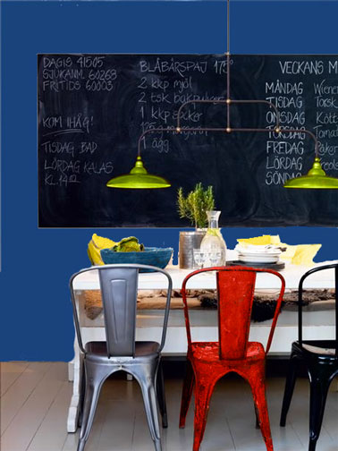 Décoration d'une cuisine de style industriel avec des couleurs en contraste : peinture murale le bleu tendance 2013, le monaco blue, chaises Tolix couleur rouge, acier, noir