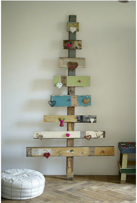 Calendrier de l'avent en forme de sapin de Noël réalisé avec des planches de récup et décoré de petits coeur et sujets rouges faits maison