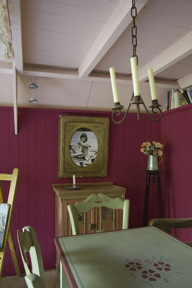 Décoration d'une salle à manger avec une peinture murale rose carmin associé avec table et chaise couleur vert bronze