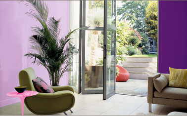 salon couleur rose violet peinture Dulux Valentine Une décoration aux couleurs vitaminées avec en peinture murale le rose Bali expression et le violet Bali intense de la collection Couleurs du Monde Dulux Valentine. En contraste, fauteuil revêtement vert