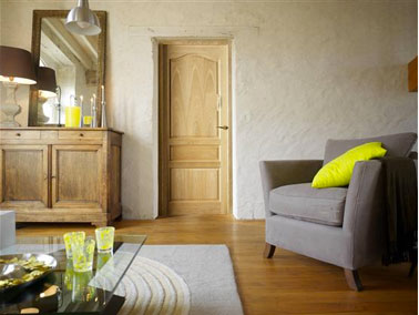 Un salon décoré autour de couleurs neutres et chaleureuses avec des murs et des textiles déclinés dans le même gris taupe de plusieurs valeurs,. Pour rehausser le tout , des touches de jaune vert acide pour le coussin et les objets de décoration