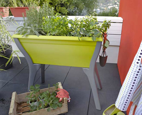 Un bac sur pieds facile à placer sur le balcon pour cultiver plantes aromatiques et fraisiers. De jolie couleur verte et grise, un carré potager qui ne prend pas de place