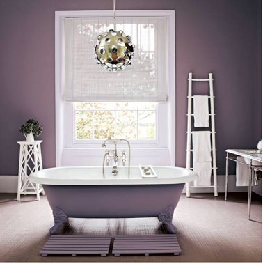Rénover baignoire et salle de bain avec une unité couleur c’est zen ! Exemple avec cette salle de bain avec une peinture baignoire dans la même teinte parme que celle utilisée pour repeindre les murs. Les accessoires déco et les boiseries blanc donnent du relief à la pièce.