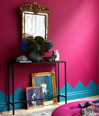 Décoration petit salon avec peinture couleur rose fushia, plinthes peintes avec motif sur mur en bleu vif. Console fer noir