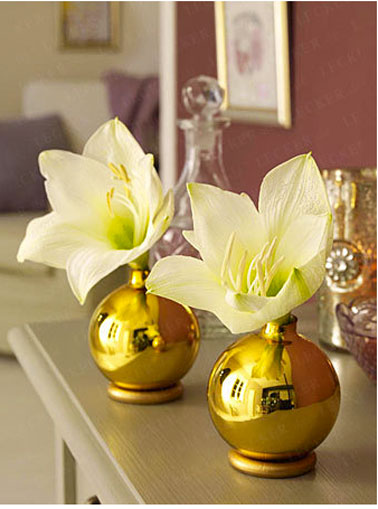 Pour la décoration de la table de Noël, un vase réalisé avec des boules dorées et des anneaux dorés à la bombe
