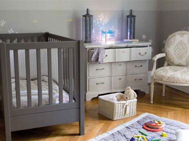Couleur taupe dans chambre bébé. Lit peinture couleur taupe, commode gris pastel. Tapis et éclairage bleu