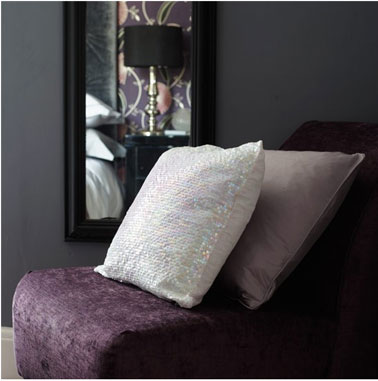 Pour les couleurs de cette chambre, le prix souris du mur est mis en valeur avec le tissu velour lit de vin du fauteuil. Le blanc des coussins et du linge de lit apportent des touches de lumière en contraste