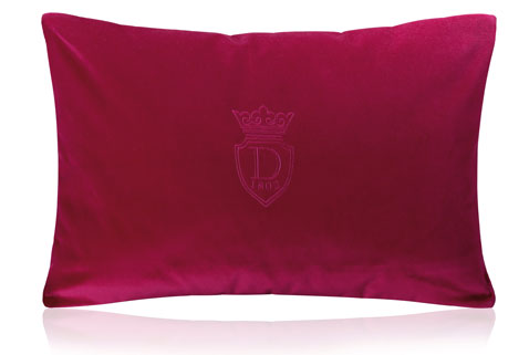 coussin en velour rouge estampillé à la marque Descamps