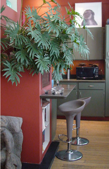 petite cuisine couleur gris et rouge brique. Meubles haut et bas ainsi que tablette bar peints en gris/vert. peinture mur et meuble four couleur rouge brique. Tabouret dans la même tonalité de gris 