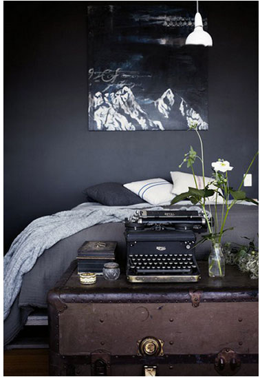 Chambre d'adultes déclinée dans des tons de noirs et gris. Aux murs, une peinture gris anthracite finition mat. Linge de lit et coussins gris et blanc.