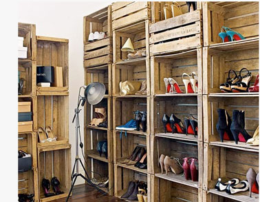 Pratique pour ranger des tas de chaussures, un dressing composé à partir de caisses en bois empilées les unes sur les autres sur toute la hauteur des murs de la pièce.