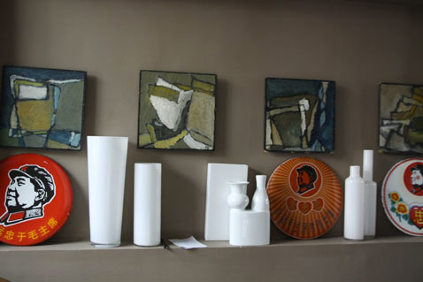 Peinture salon : Associer une couleur taupe avec du rouge vert et blanc pour mettre en valeur la décoration d'une cheminée. Peinture murale couleur taupe, éléments de décoration vert et rouge, vases blanc