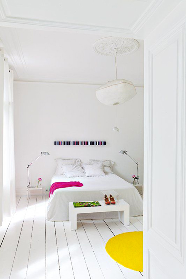 Peindre le parquet d'une chambre adulte en blanc avec un grand cercle de peinture jaune pour une touche contemporaine