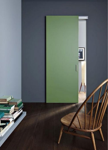 Porte de communication entre salon salle à manger peinte en vert jade en harmonie avec le gris perle et le gris anthracite des murs. Au sol, parquet wengé