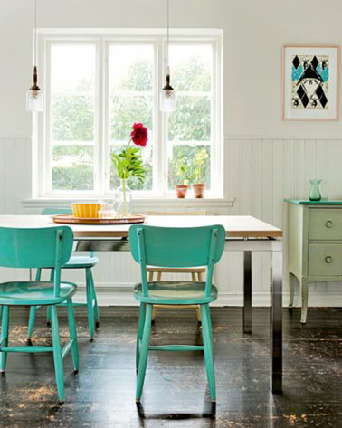Du vert et du blanc pour relooker une salle à manger dans un esprit récup. Autour de la table bois repeinte en blanc et ses pieds passés à la peinture en bombe noire, les chaises repeintes en vert printemps font écho au dessus du buffet. 