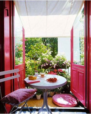 balcon sur salon harmonie de rose et de fushia, plantes suspendues dans jardinières accrochées à rambarde