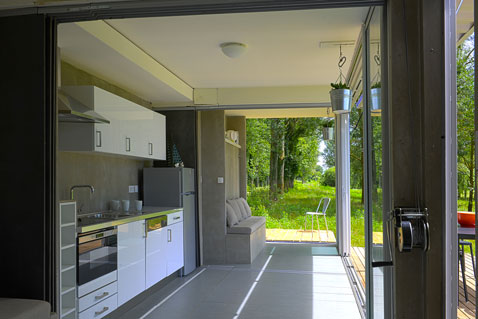 Espace cuisine aménagée dans container volume ouvert sur de grandes baies vitrées