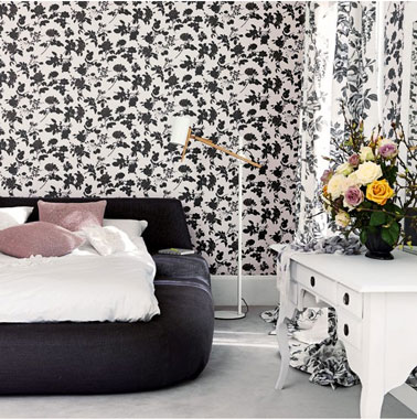 Du papier peint pour une déco de chambre noir et blanc avec motifs rideaux assorti. La Tête de lit noire et la commode blanche apporte la sobritété.