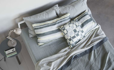 déco de chambre dans une belle harmonie de gris pastel et blanc. Le parquet, les murs sont peints dans le même gris tendre, le linge de lit reprend le thême du gris dans des tonalités légèrement plus soutenues. Les taies d'oreiller à rayures et carreaux apportent une touche de fantaisie dans cet univers monochrome