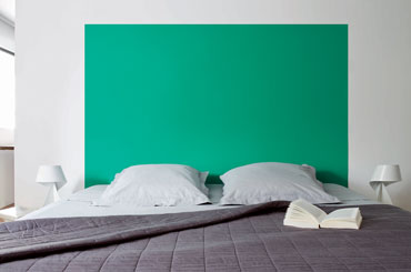 Couleur peinture chambre. Tête de lit peinte en vert émeraude sur mur blanc. Dessus de lit damassé gris souris