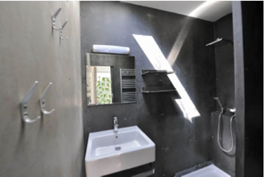 Salle de bains dans container Volume comprenant cabine de douche, grand lavabo et WC suspendus chasse d'eau 2 débits.