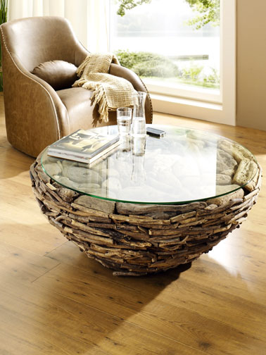 déco zen pour ce salon autour du bois et des couleurs naturelles. Fauteuil cuir, table ronde en bois flotté parquet au sol et plaid écru