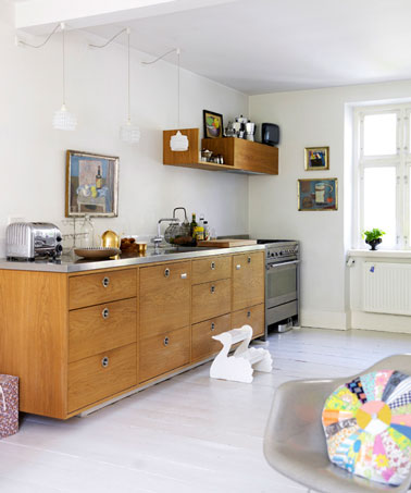 Décoration d'une cuisine dans le pur style scandinave, les meubles bas et l'étagère en chêne massif  vernis clair tranchent avec le blanc de la peinture murale et celui du parquet